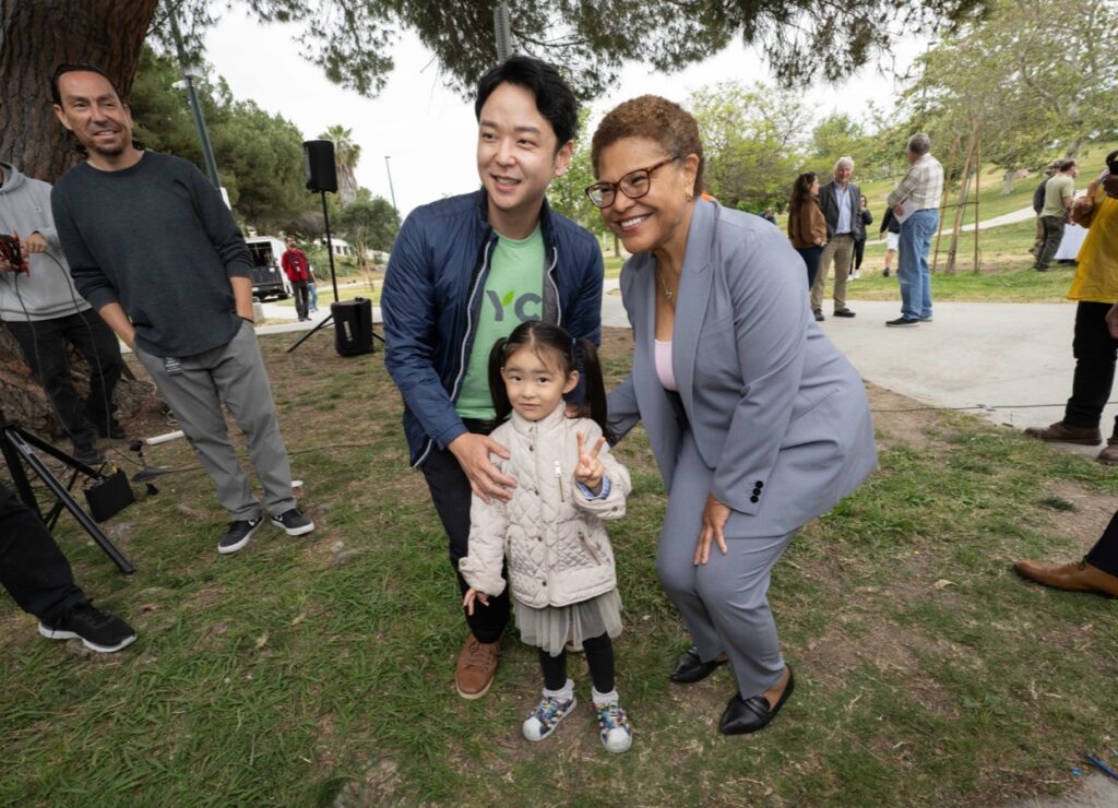 Mayor Karen Bass taking photo with little girl and father at park